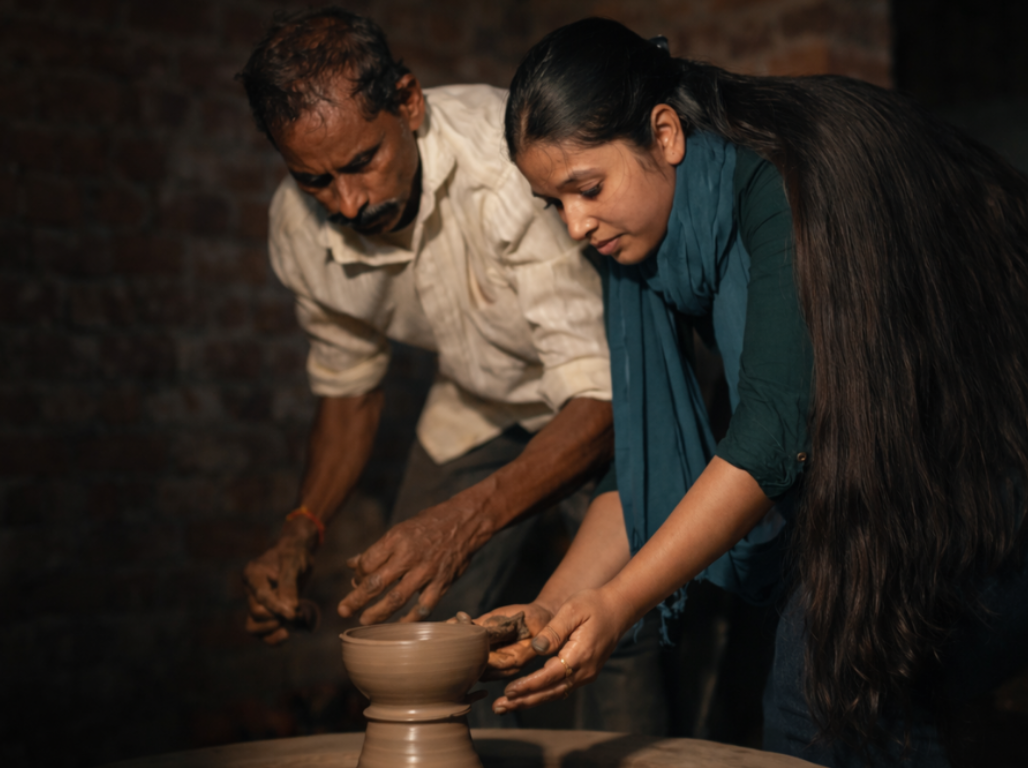 Master potter guiding a young woman shaping a pot on the wheel