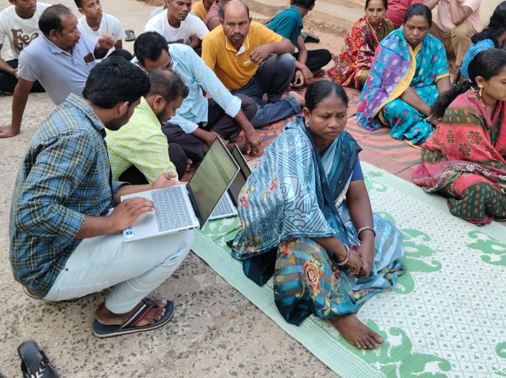 A researcher recording knowledge with a community member on a laptop