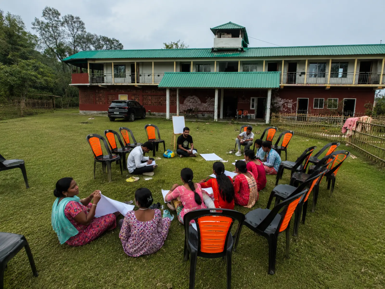 Residential camp group seated in a circle at work on the Vanabas lawn