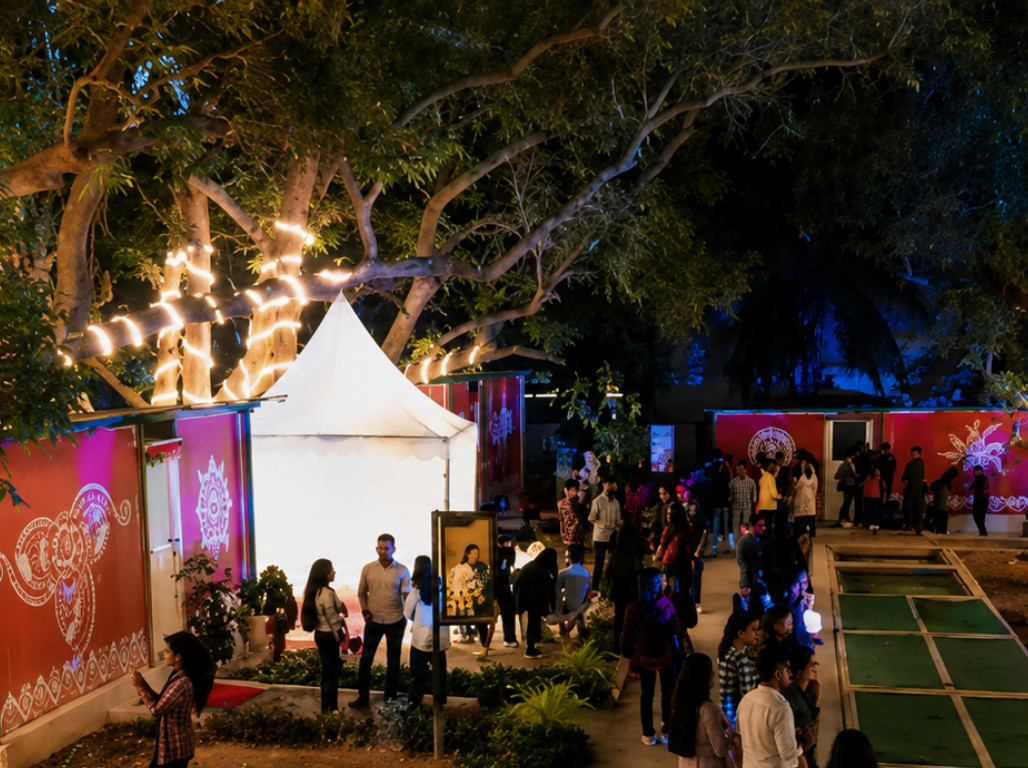 Evening book fair pavilion under lit trees with visitors browsing stalls