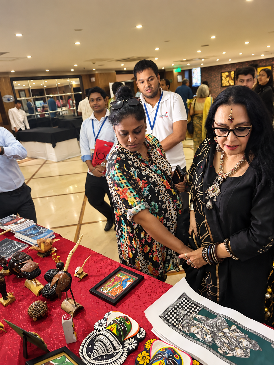 Visitors viewing handcrafted products and paintings at an MTF stall