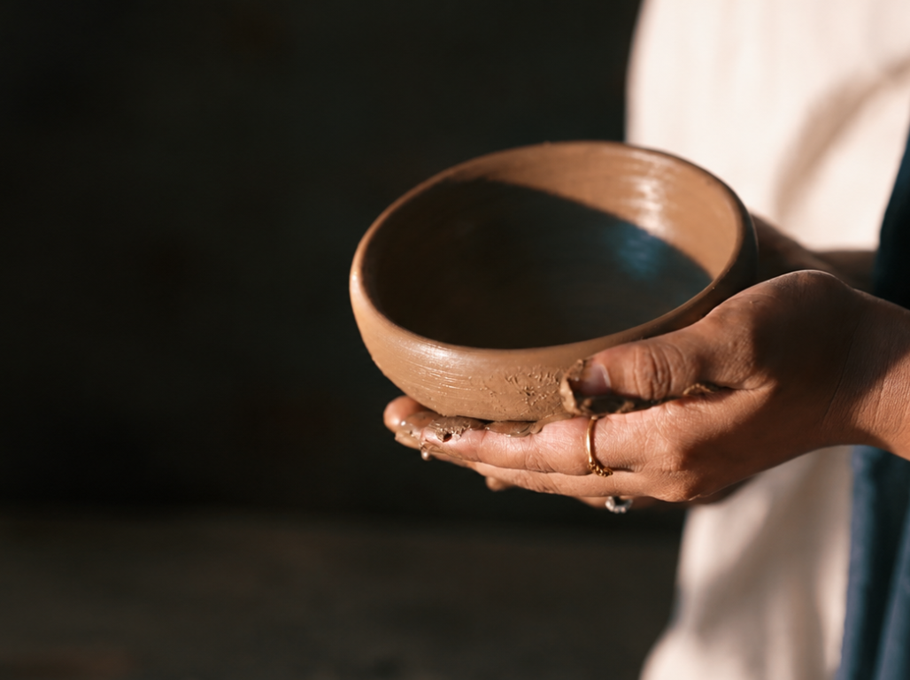Hands holding a freshly thrown clay bowl
