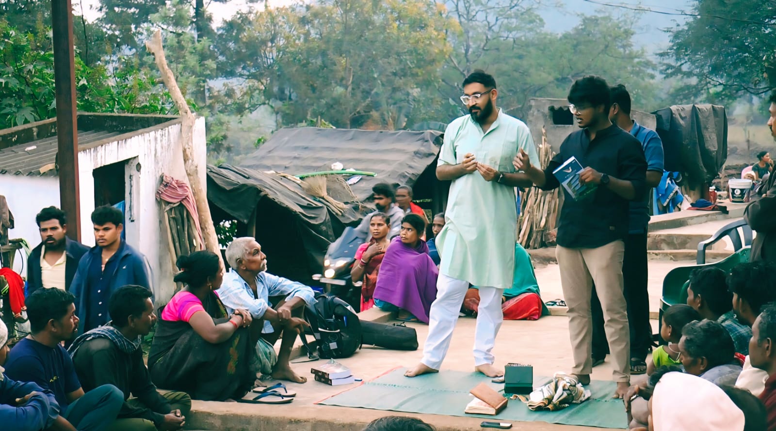 Facilitators addressing a village gathering during a camp