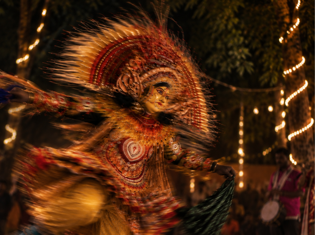 A masked performer in a golden costume mid-spin during a night performance