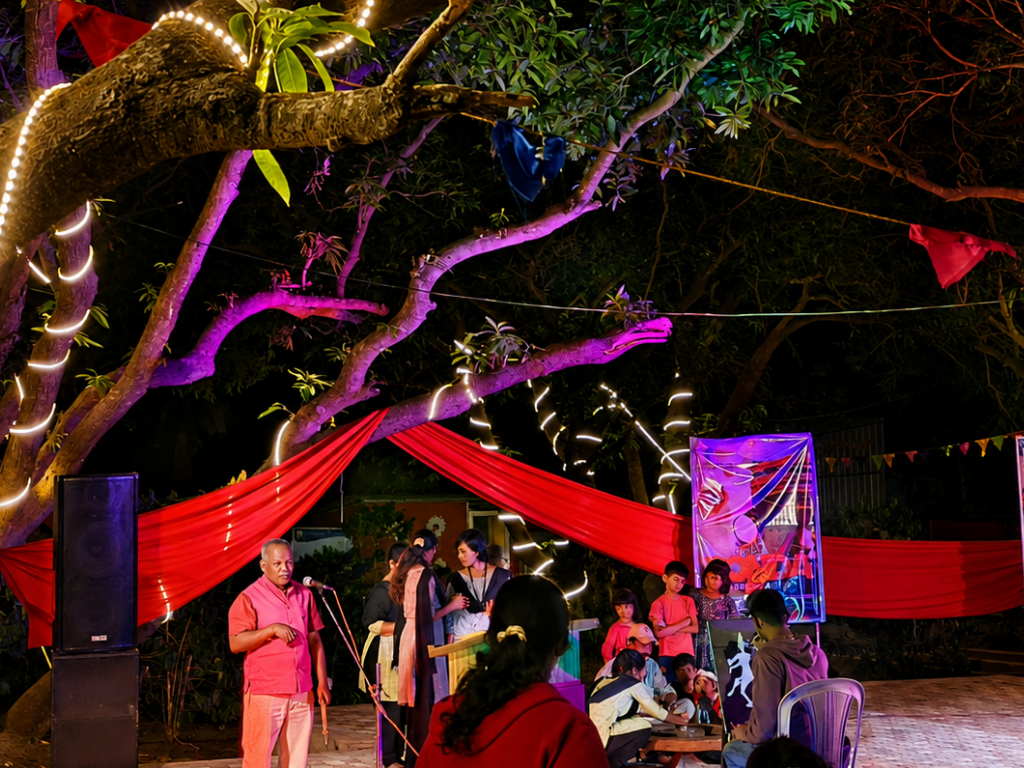 Outdoor evening performance under a lit tree at the Bodh Kendra