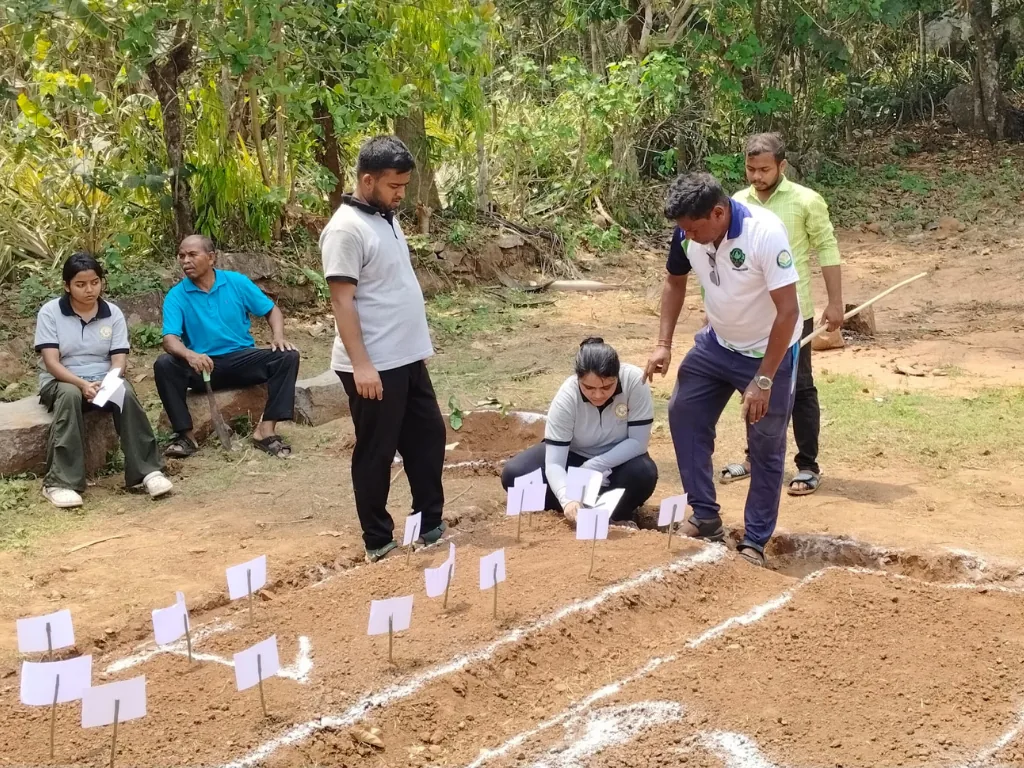 Community members marking a prepared garden bed during an agro-ecology research session