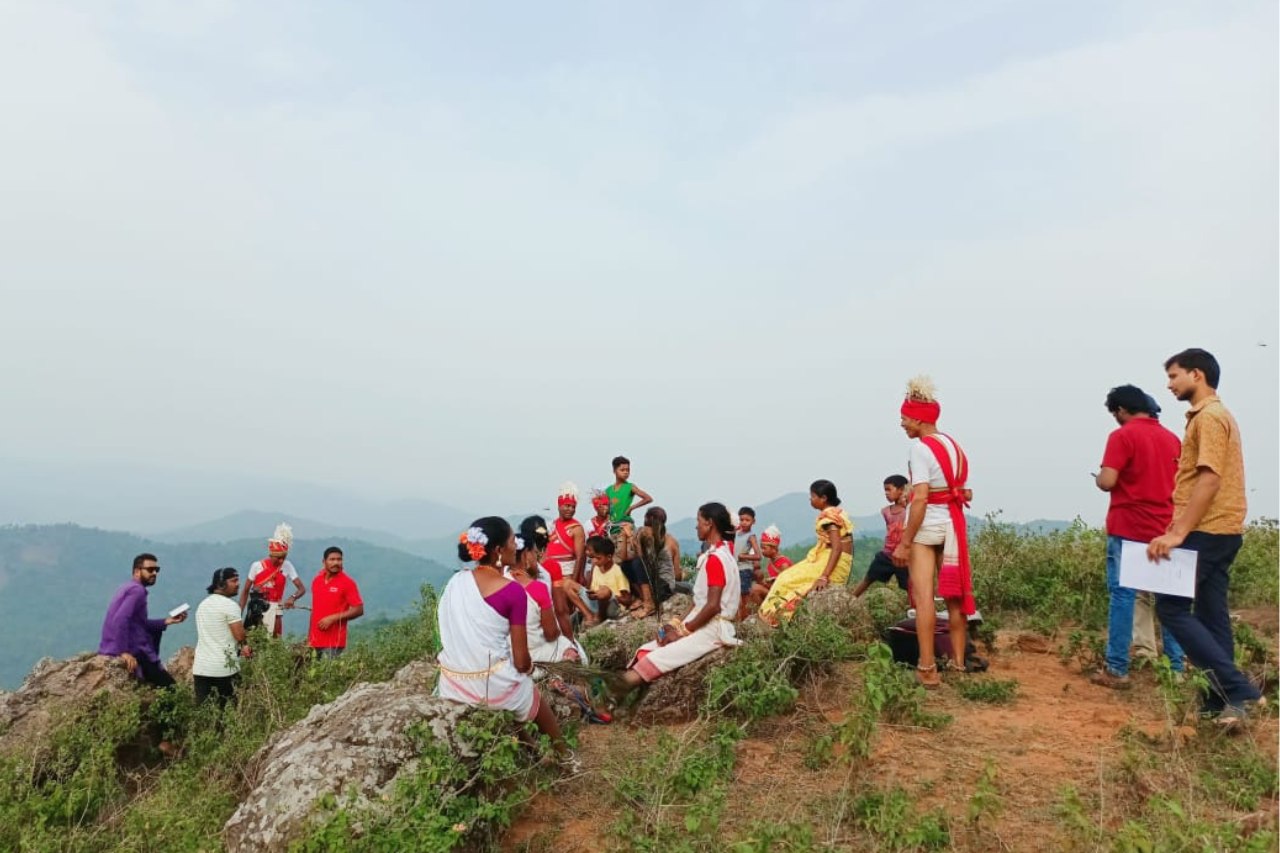 about-04 Two tribal women in vibrant traditional clothing holding plants in Odisha, India.